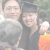 A graduate has her picture taken while holding flowers after commencement 2004.